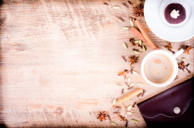 Cake and cup of coffe with spices, cinnamon, cloves, cardamom, anise and notebook on wooden background. Eating frame. Morning. Free space for text