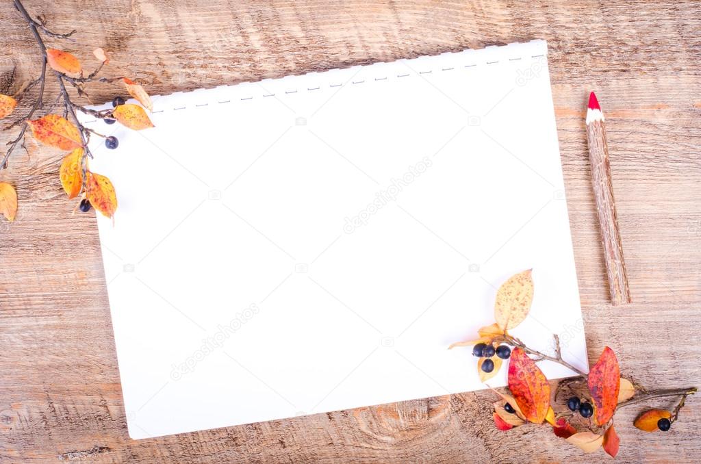 Colorful autumn leaves and pensil lying on diary, notebook, paper, wooden background. Fall and thanksgiving. Autumn composition. Free space for text.