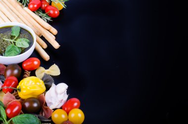 Ingridients for traditional italian dishes on black background. Free space for your text