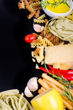 Ingridients for traditional italian dishes on black background. Free space for your text