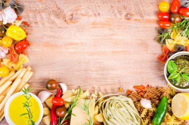 Ingridients for traditional italian dishes on wooden background. Free space for your text