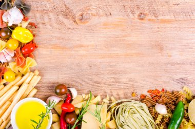 Ingridients for traditional italian dishes on wooden background. Free space for your text
