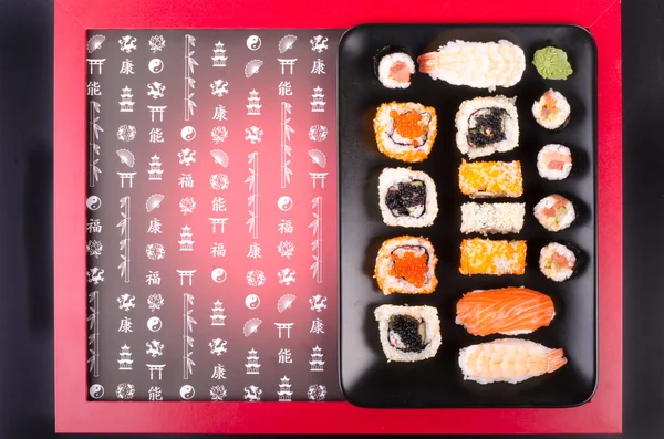Sushi set served on a plate, soy cheese, lime on black background with red frame — ストック写真