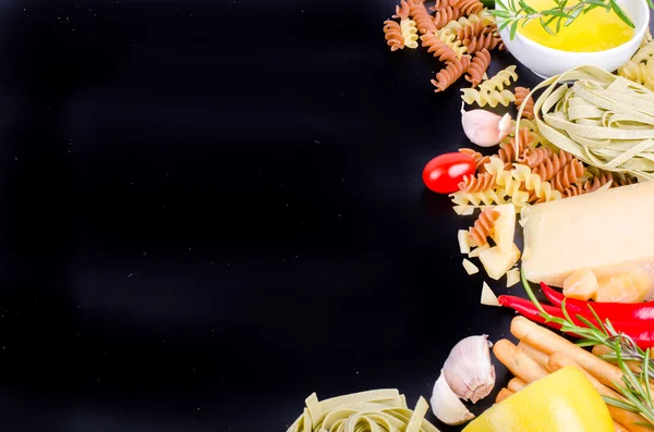 Ingridients for traditional italian dishes on black background. Free space for your text