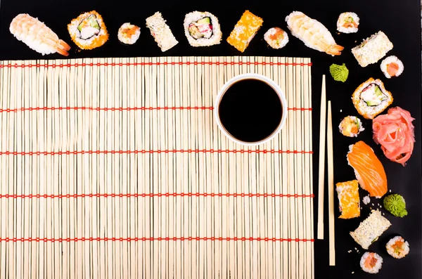 Set de sushi, queso de soja, lima, aguacate, jengibre, caviar rojo, caviar negro, salsa de soja, wasabi sobre fondo negro —  Fotos de Stock