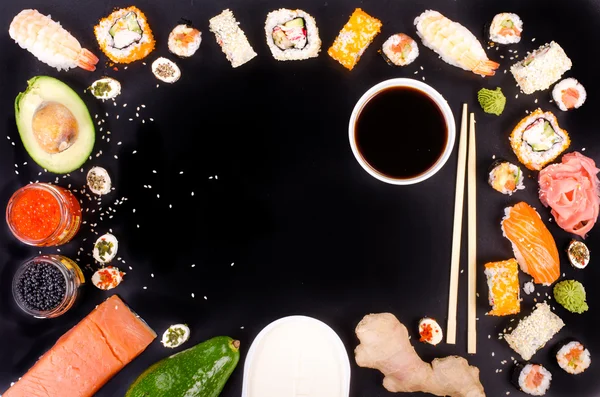 Sushi set, soy sauce, ginger, wasabi on black background. Free space for your text. Food frame