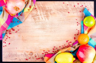 Fresh fruits on wooden background. Summer background. Raw and vegetarian eating background. Lemon, apple,  grapefruit, pomegranate, lime, persimmon, tangerine, orange, pink pepper. Top view