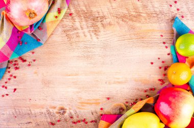Fresh fruits on wooden background. Summer background. Raw and vegetarian eating background. Lemon, apple,  grapefruit, pomegranate, lime, persimmon, tangerine, orange, pink pepper. Top view