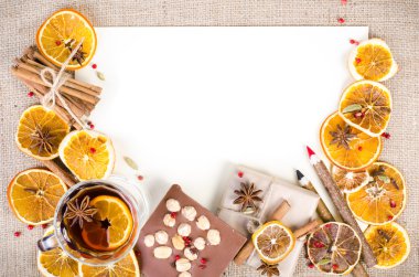 Dried oranges, cinnamon, cloves, cardamom, handmade milk chocolate with nuts, mulled wine, wooden pencil, list of paper on sackcloth, canvas. Christmas, New Year and winter. Free space for your text.