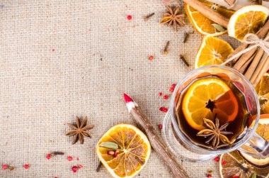 Dried oranges, cinnamon, cloves, cardamom, handmade milk chocolate with nuts, mulled wine, wooden pencil, list of paper on sackcloth, canvas. Christmas, New Year and winter. Free space for your text.