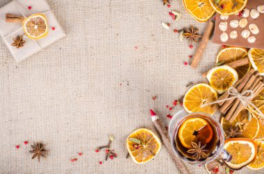 Dried oranges, cinnamon, cloves, cardamom, handmade milk chocolate with nuts, mulled wine, wooden pencil, list of paper on sackcloth, canvas. Christmas, New Year and winter. Free space for your text.