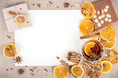 Dried oranges, cinnamon, cloves, cardamom, handmade milk chocolate with nuts, mulled wine, wooden pencil, list of paper on sackcloth, canvas. Christmas, New Year and winter. Free space for your text.
