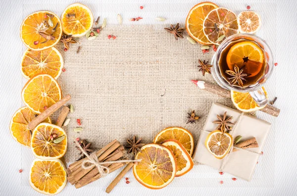 Dried oranges, cinnamon, cloves, cardamom, handmade milk chocolate with nuts, mulled wine, wooden pencil on sackcloth, canvas. Christmas, New Year and winter. Free space for your text.