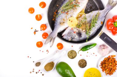 Fresh raw gilthead fishes with lemon, herbs, salt on white background. Healthy food concept. Food frame. Free space for your text.
