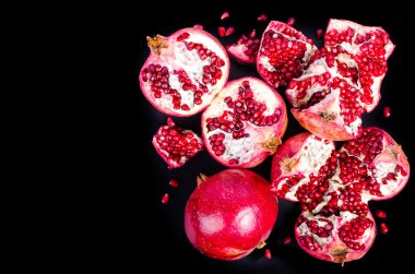 Kırmızı sulu nar, bütün, yarım, Olgun ve kırık meyve siyah arka plan üzerine. Metniniz için boş alan.