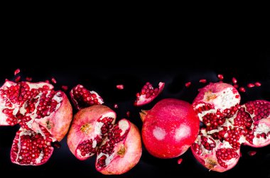 Kırmızı sulu nar, bütün, yarım, Olgun ve kırık meyve siyah arka plan üzerine. Metniniz için boş alan.