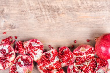 Kırmızı sulu nar, bütün, yarım, Olgun ve kırık meyve ahşap arka plan üzerinde. Metniniz için boş alan.