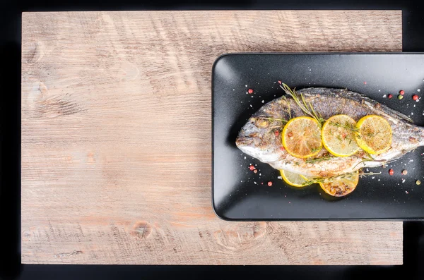 Roasted gilthead fishes with lemon, herbs, salt on wooden background. Healthy food concept. Food frame. Free space for your text. — Φωτογραφία Αρχείου