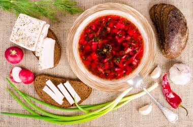 Tuzlanmış taze domuz yağı, sarımsak, yeşil soğan, kırmızı biber ve çavdar ekmeği çuval bezi, tuval arka plan ile kase de pancar çorbası. 