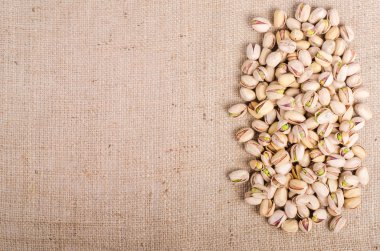 Çuval bezi üzerine tuz antep fıstığı, tuval arka plan. Metniniz için boş alan.