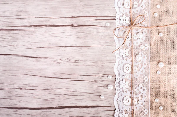 Spetsar, pärlor, Bowknot, canvas, säckväv på trä bakgrund. Rustik design. Ledigt utrymme för din text — Stockfoto