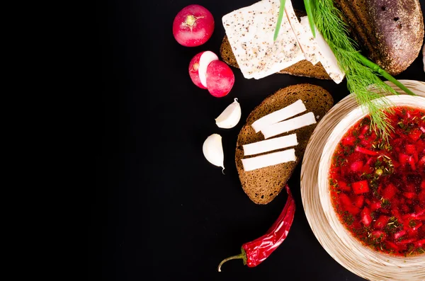 Ukrainian beetroot soup - borscht in bowl with salted fresh lard - salo, garlic, green onion, red pepper and rye bread on black background. — Stock Image Ukrainian beetroot soup - borscht in bowl with salted fresh lard - salo, garlic, green onion, red pepper and rye bread on black background. Stock Photo