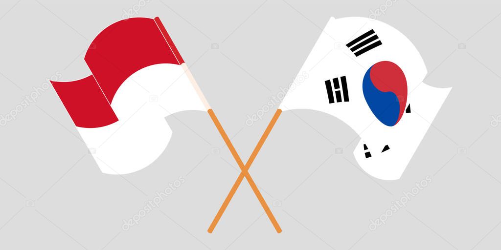 Crossed and waving flags of Indonesia and South Korea