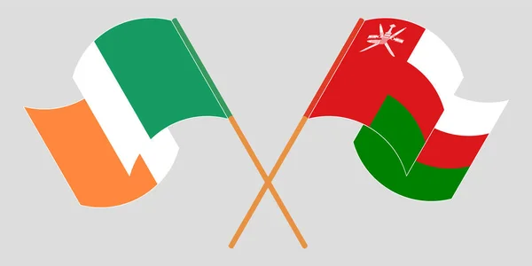 Banderas cruzadas y ondeantes de Omán e Irlanda — Vector de stock