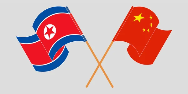 Banderas cruzadas y ondeantes de Corea del Norte y China — Vector de stock