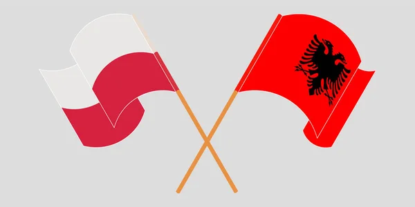 Bandeiras cruzadas e onduladas da Albânia e da Polónia — Vetor de Stock