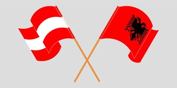 Křížené a vlnící se vlajky Albánie a Rakouska — Stockový vektor