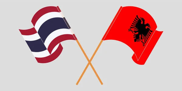 Bandeiras cruzadas e onduladas da Albânia e da Tailândia — Vetor de Stock