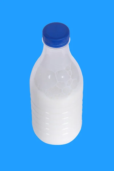 Пляшка молока на синьому фоні — стокове фото