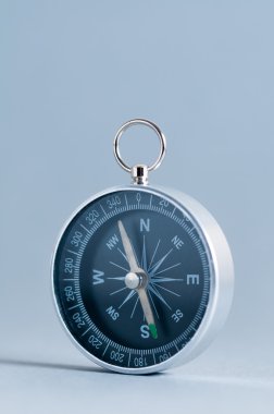 Gri arka plan üzerinde pusula. Dikey.