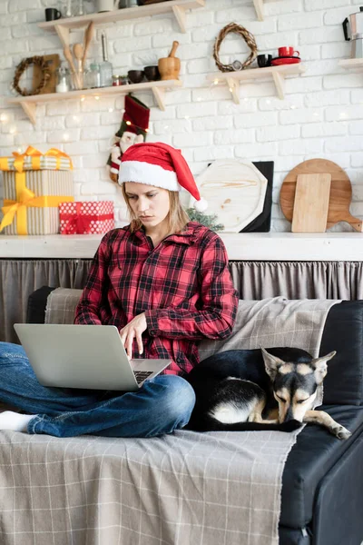 Christmas Saludos Línea Joven Rubia Santa Hat Trabajando Portátil Sentado — Foto de Stock