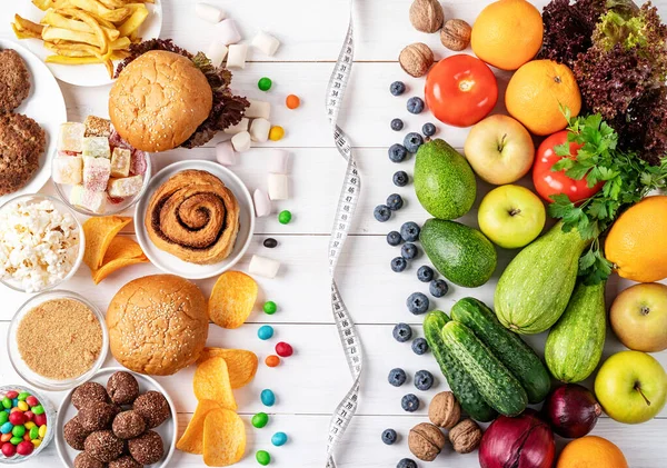 Frutas y verduras vs dulces y comida rápida vista superior plana laico — Foto de Stock