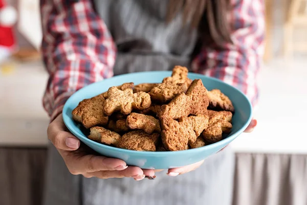 Woman hands holding a plate with home baked cookies in the kitchen — Stock Photo, Image