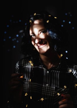 Işık ve gölge portresi. Siyah arka planda yüzü sabun köpüğü desenli güzel bir kadın.