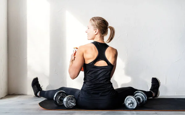 健康的生活方式运动和健身 年轻金发女子带着哑铃锻炼的后视镜 她的后背和胳膊肌肉都显示出来了 — 图库照片
