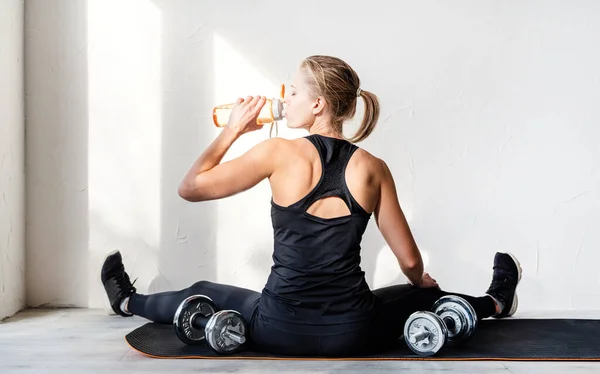 健康的生活方式运动和健身 年轻金发女子带着哑铃锻炼的后视镜 她的后背和胳膊肌肉都显示出来了 — 图库照片