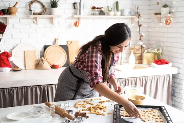 Cooking and baking. Young brunette woman baking cookies at the kitchen