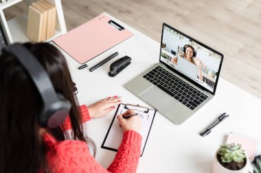 Mesafe öğrenme. E-öğrenme. İnternette bilgisayar kullanarak İngilizce öğreten kadın