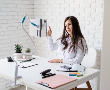 Mesafe öğrenme. E-öğrenme. İnternette tablet kullanarak İngilizce öğreten kadın