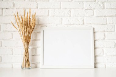 Poster şablonu beyaz tuğla duvar zemininde buğday süslemesiyle aynı. Boşluğu kopyala