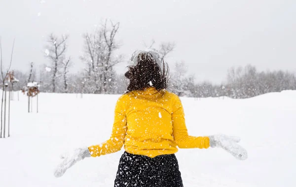 Jovem morena brincando com neve no parque — Fotografia de Stock