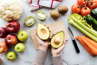Kilo verme ve diyet yapma konsepti. Avokado tutan kadın eller detoks diyeti üst görünüm düz yatıyor