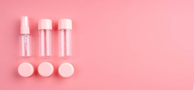 Boş plastik şişeler ve kozmetik için tüpler pastel pembe arka planda fotokopi alanı, üst görünüm düzlüğü, pankart