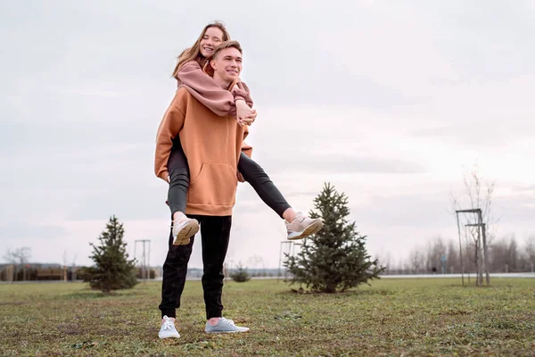 Parkta Birbirini Kucaklayan Kapüşonlu Mutlu Genç Çift Eğleniyor — Stok fotoğraf