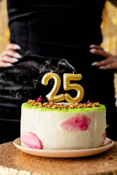 Birthday party. Woman in black party dress ready to eat birthday cake celebrating her twenty fifth birthday