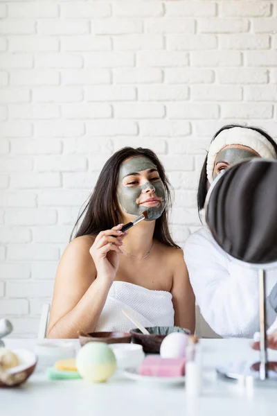 Potret seorang wanita cantik menerapkan masker wajah melakukan prosedur spa — Stok Foto